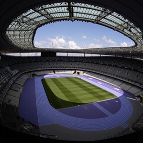 Una vista panor&aacute;mica del Stade de France en Saint-Denis, Par&iacute;s, que muestra su ic&oacute;nica pista de atletismo sint&eacute;tica de color p&uacute;rpura que rodea un campo de f&uacute;tbol verde y exuberante, bajo un gran techo abierto con scatter.jpg